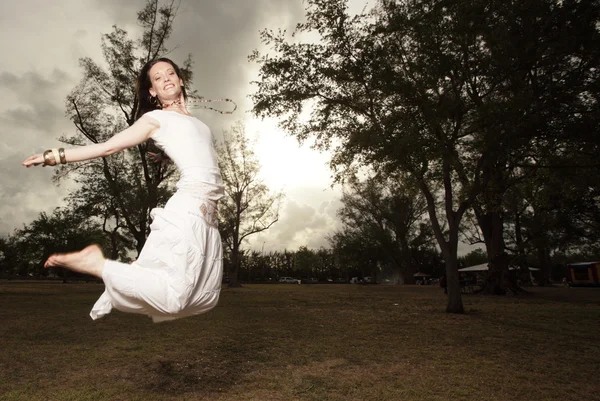 Mujer saltando en un entorno de parque — Foto de Stock