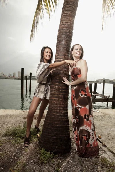 Twee modellen poseren door een palmboom — Stockfoto
