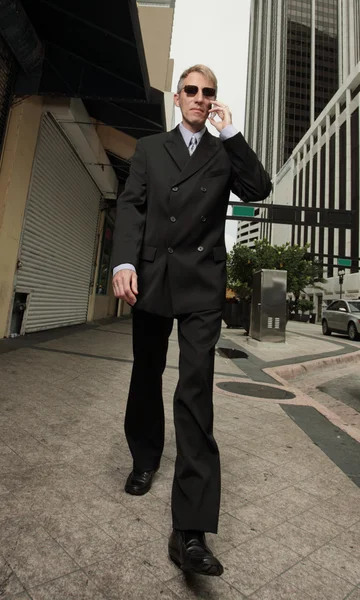 Empresário andando e falando ao telefone — Fotografia de Stock