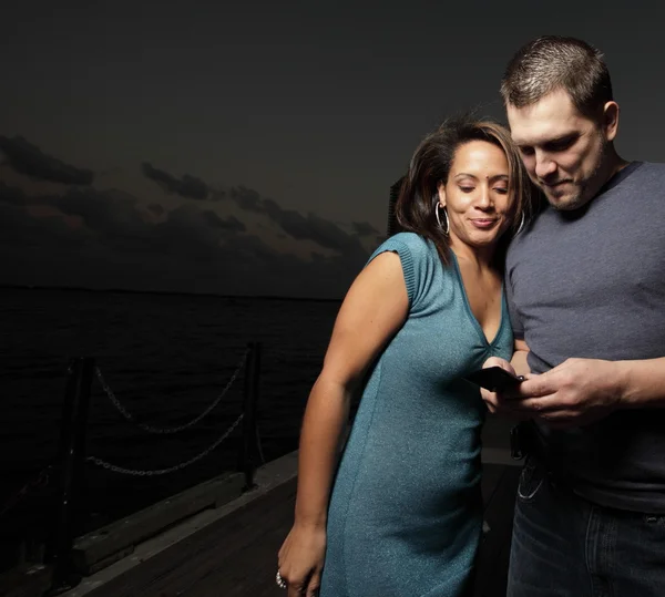 Paar schaut auf ein Handy — Stockfoto