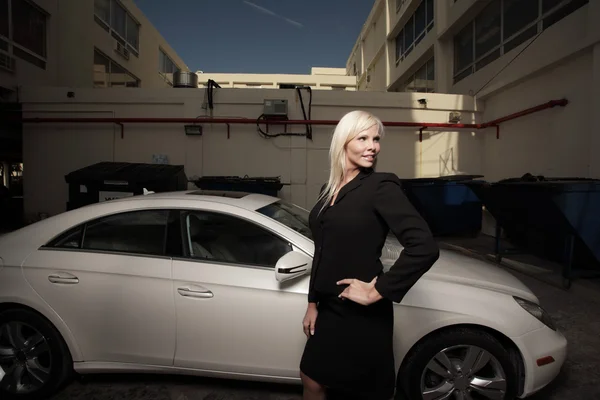 Vrouw poseren door een auto in het steegje — Stockfoto