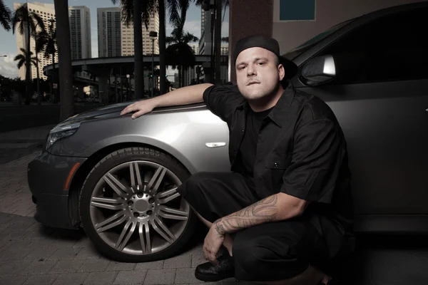 Young gangster posing by a sports car — Stock Photo, Image