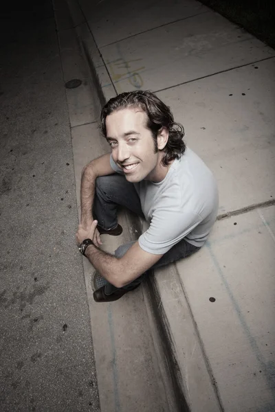Man sitting on the curb — Stock Photo, Image