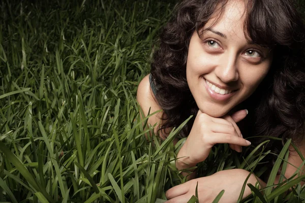 Femme allongée sur l'herbe et souriante — Photo