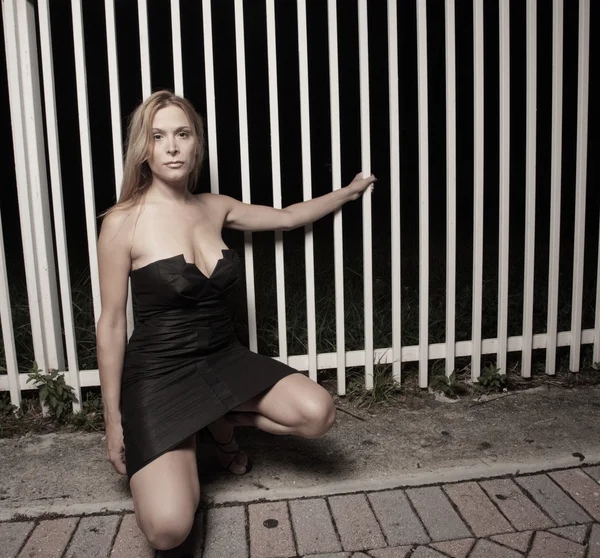 Mooie vrouw poseren in een zwarte jurk — Stockfoto