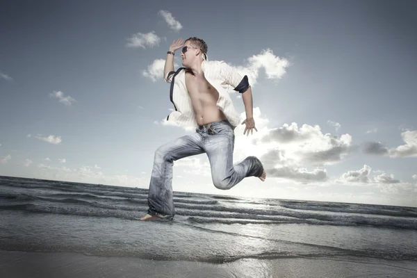 Mann läuft am Strand — Stockfoto