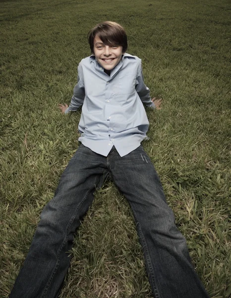 Pojken sitter på gräset — Stockfoto