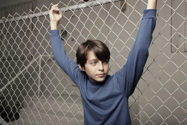 Junge posiert an einem Zaun — Stockfoto