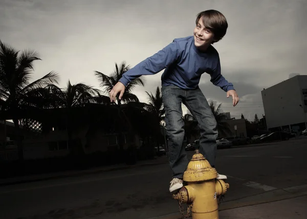 Мальчик на пожарном гидранте — стоковое фото