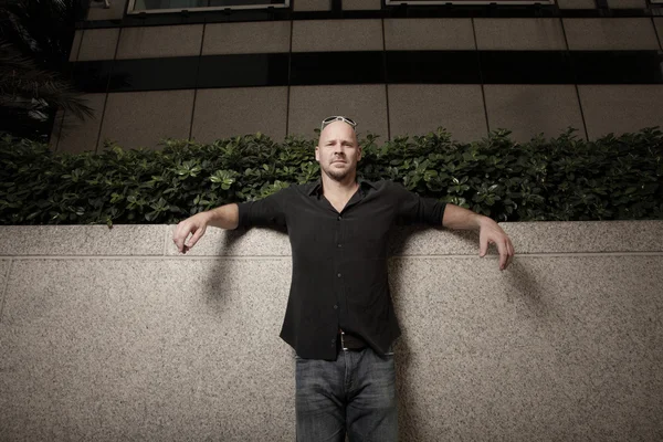 Man posed by a building ledge — Stock Photo, Image