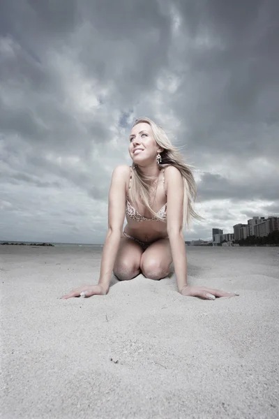 Žena klečí na písku — Stock fotografie