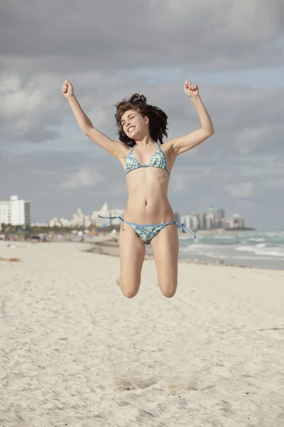 Frau springt an den Strand — Stockfoto