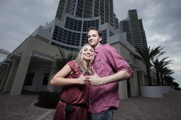 Jovem casal em roxo mostrando polegares para cima — Fotografia de Stock