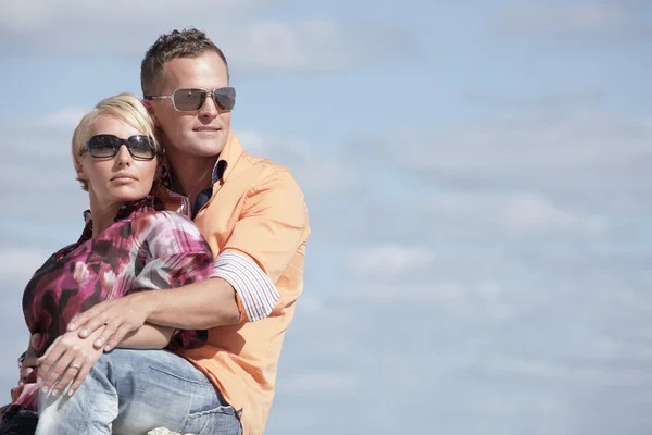 Mladý pár na zatažené obloze modré — Stock fotografie