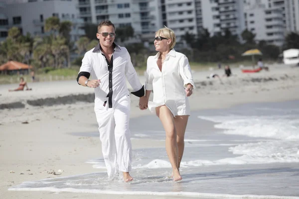 해변을 걷고 있는 젊은 부부 — 스톡 사진