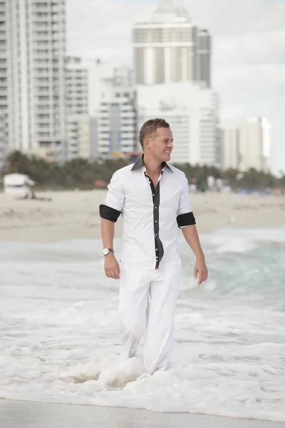 浜で歩くと笑みを浮かべて男 — ストック写真