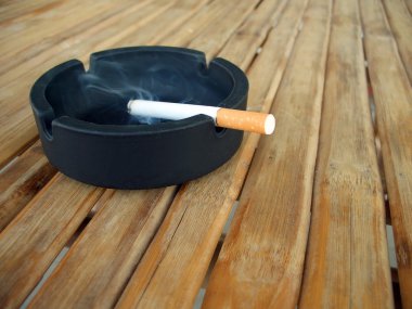 yanan bir sigara ile kül tablası