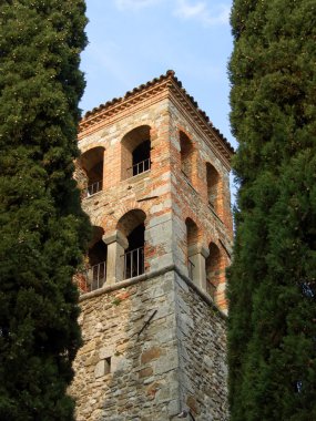 Bell tower between cypresses clipart