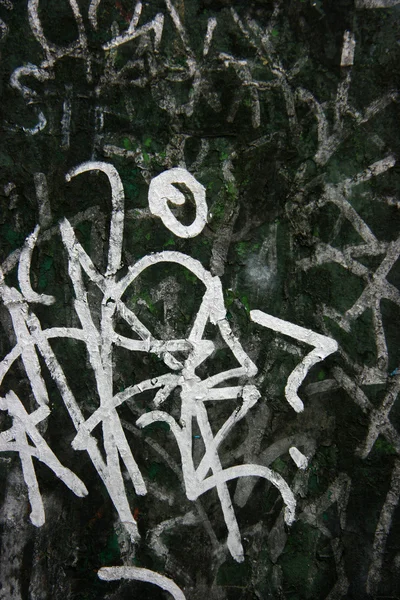 Białe graffiti na ciemno zielone — Zdjęcie stockowe