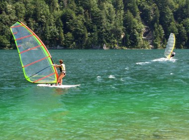 Windsurfers in a mountain lake clipart