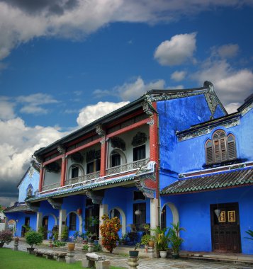 Chinese blue mansion under cloudy sky clipart