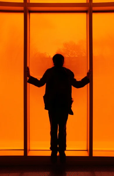 Siluett framför orange fönster — Stockfoto