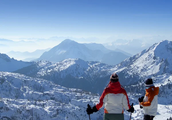 Two skiers looking over mountains top — Stock Photo, Image
