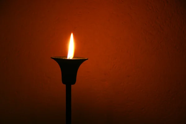 Свеча над красной стеной — стоковое фото