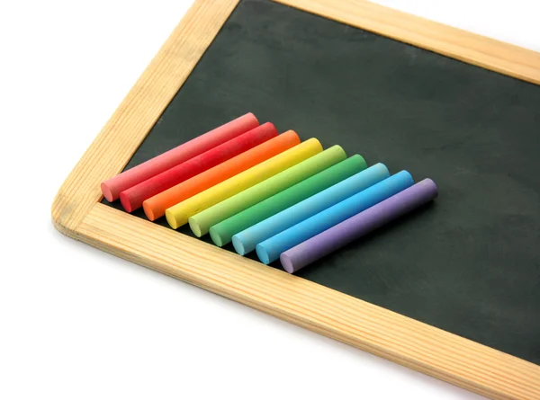 Blackboard en krijtjes in regenboog — Stockfoto
