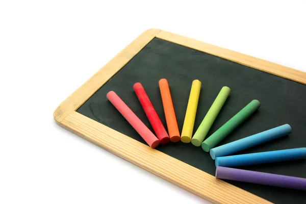 Blackboard and chalks in rainbow — Stock Photo, Image