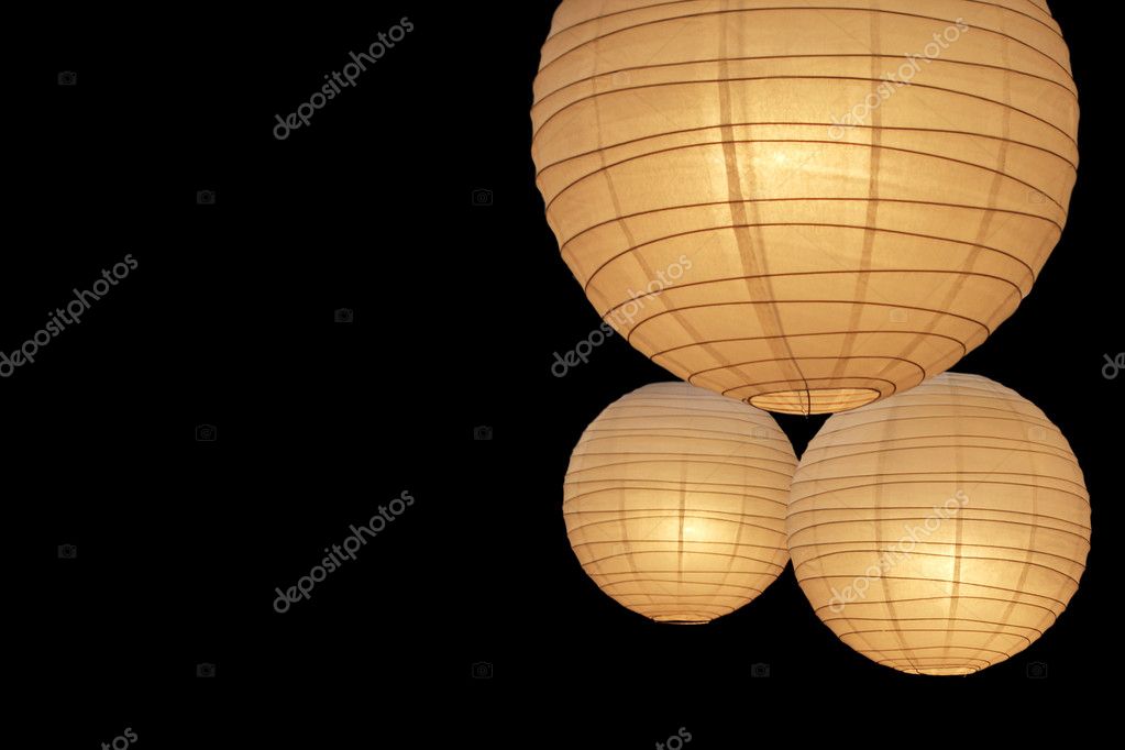 孤立在黑色背景上的三个热烈彩色的气球纸灯 图库图片