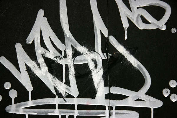 Bílé graffiti na černém — Stock fotografie