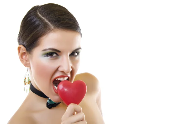 Привлекательная женщина, кусающая красное сердце — стоковое фото