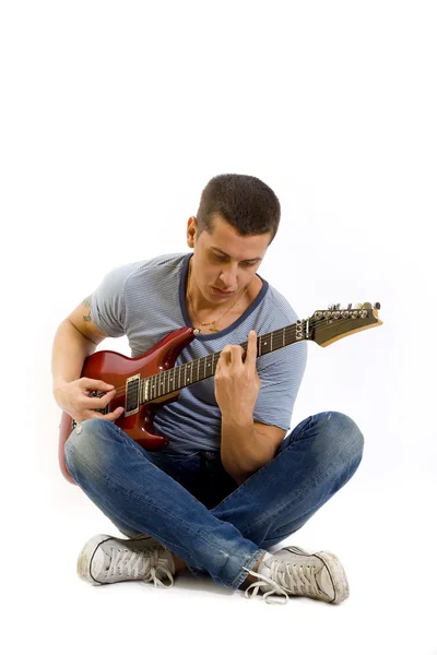 Siedzi gitarzysta gra — Zdjęcie stockowe