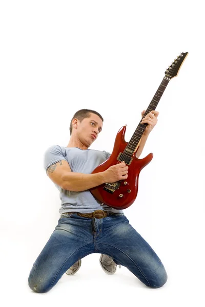Гитарист на коленях играет на гитаре — стоковое фото