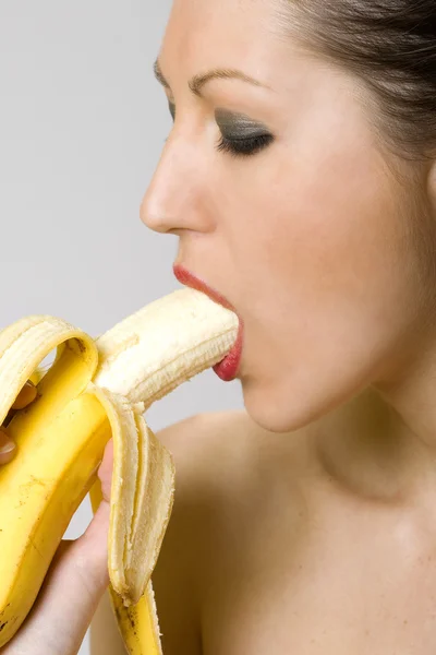Junge Frau isst Banane — Stockfoto