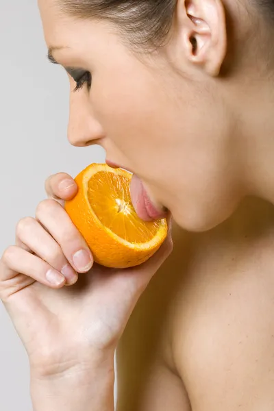 Жінка облизує апельсин — стокове фото