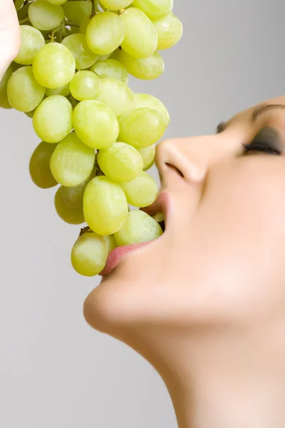 Woman biting grapes — Stock Photo, Image