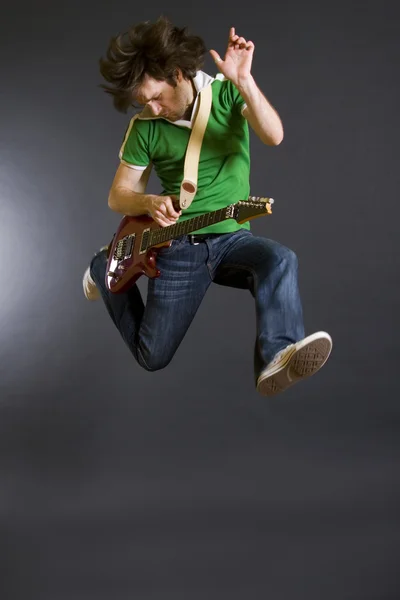 Passionate guitarist jumps in the air - Stock Image - Everypixel