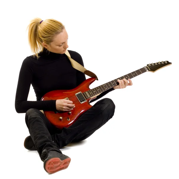 Menina tocando uma guitarra elétrica sentada — Fotografia de Stock