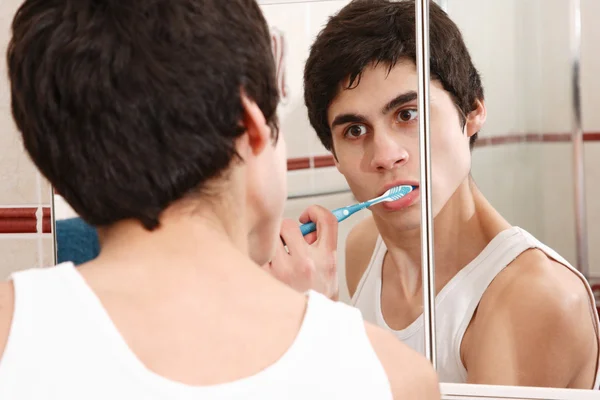 Молодий чоловік чистить зуби — стокове фото