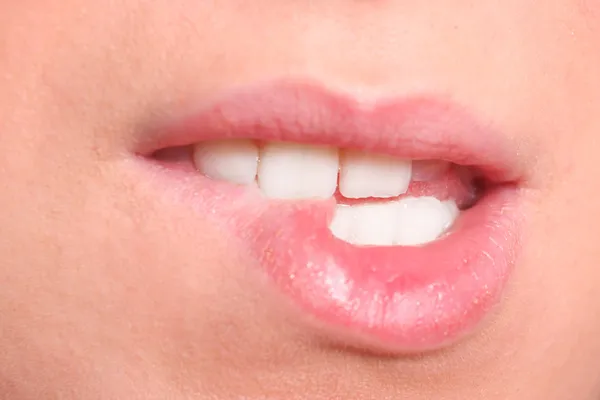 Close-up van vrouw kauwen lippen — Stockfoto