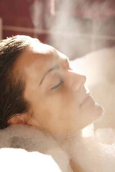 Jonge vrouw geniet badschuim — Stockfoto
