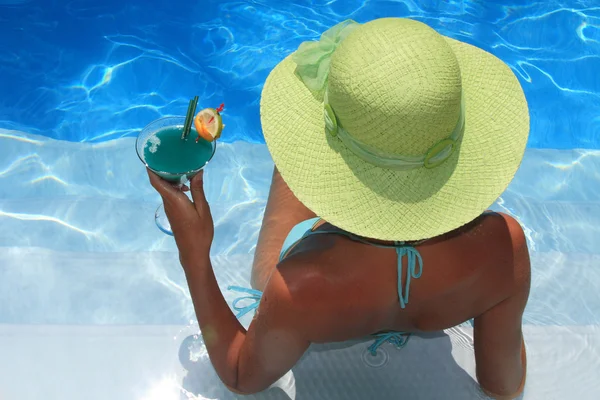 Vrouw liggen in blauwe zwembad — Stockfoto