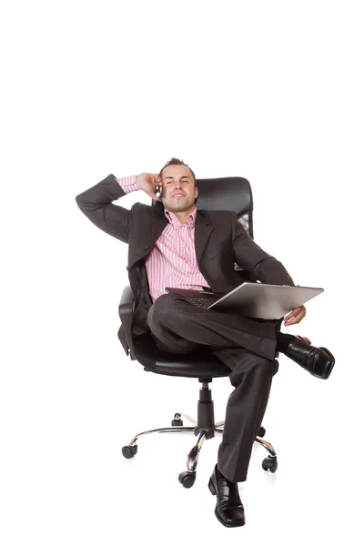 Расслабленный молодой бизнесмен, сидящий на стуле . — стоковое фото