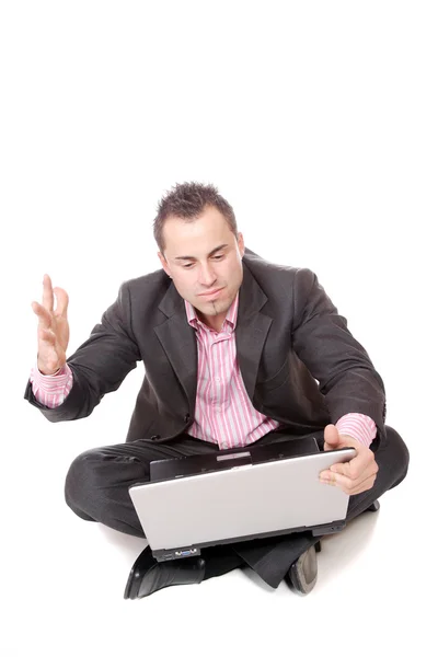 Νεαρός άνδρας με φορητό υπολογιστή που κάθεται στο πάτωμα. — Φωτογραφία Αρχείου
