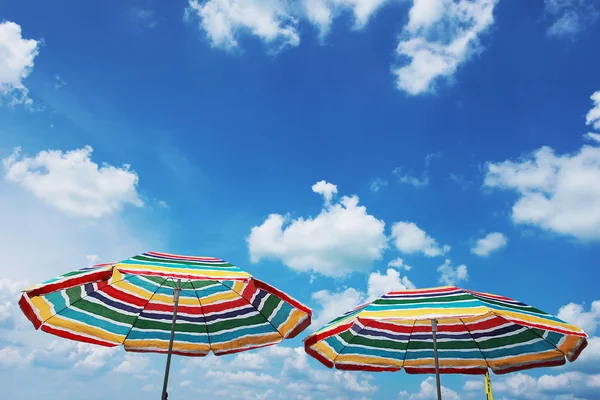 Dos sombrillas de playa y cielo azul nublado —  Fotos de Stock
