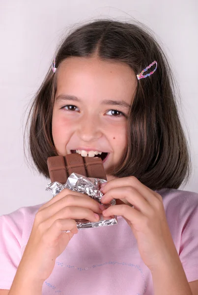 Mladá dívka jí balíček čokolády — Stock fotografie
