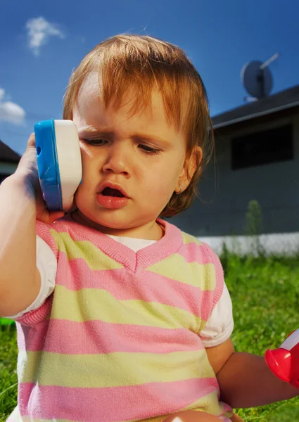 Маленький ребенок с игрушечным телефоном — стоковое фото