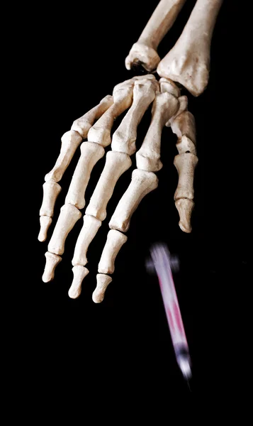 Skelett hand släppa en cigarett — Stockfoto